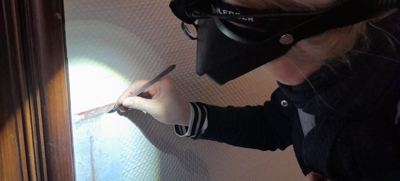 Die Restauratorin Tanja Pieper-Beenken legt einen Teil der ursprünglichen Farbschichten des Treppenhauses frei