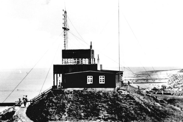 Schwarz-weiß Fotografie einer Wetterstation auf einer Anhöhe