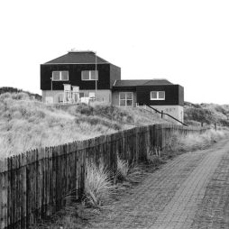 Neubau der Wetterwarte 1981 (Foto: Stadtarchiv Norderney) Schwarz-weiß Fotografie eines Gebäudes, davor ein eingezäunter Weg