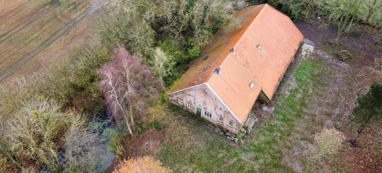 Gulfhof aus der Vogelperspektive, umgeben von Feldern und Bäumen